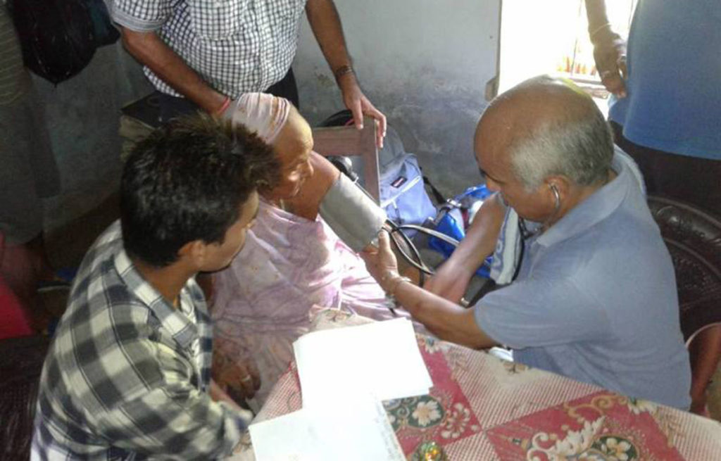 सप्तरीका जिल्लाको तिलाठी गाविसका बाढीपीडितलाई नि:शुल्क स्वास्थ्य उपचार गर्दै डा.गोबिन्द केसी । तस्बिर : अरुण कुमार यादव, राजविराज, रासस