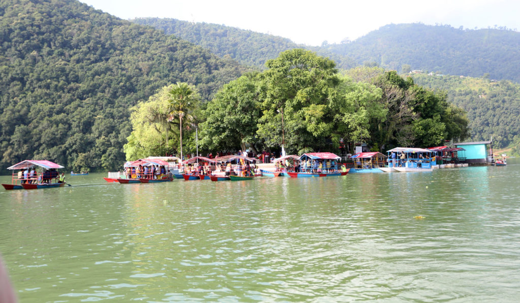 फेवातालको विचमा रहेको ताल वाराही मन्दिर दर्शन गर्न आवत जावतमा प्रयोग गरिने डुङगाहरु सर्वसाधारण वोकेर मन्दिर तर्फ जादै । तस्बिरः प्रदीपराज वन्त,रासस